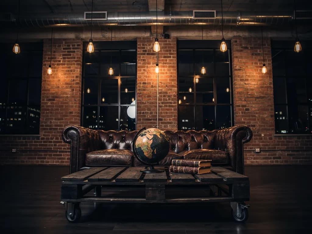 A loft style sample: a brick wall, a leather Chesterfield and filament bulbs on cords