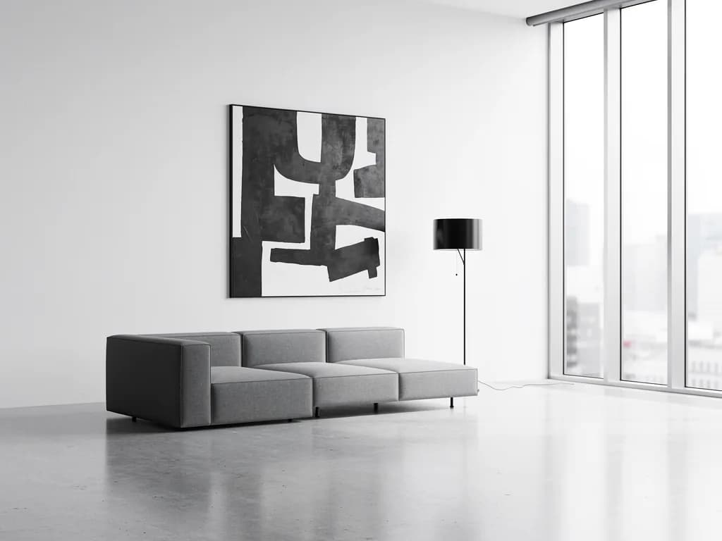 A minimalist sample: white walls, a grey modular sofa and one black-and-white painting